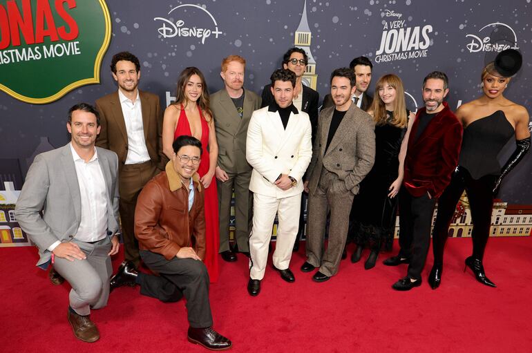 Scott Morgan, Spencer Berman, Randall Park, Chloe Bennet, Jesse Tyler Ferguson, Nick Jonas, Joe Jonas, Kevin Jonas, Isaac Aptaker, Elizabeth Berger, Adam Fishbach y Laverne Cox en el estreno de "A Very Jonas Christmas Movie" en Nueva York. (Dia Dipasupil/Getty Images/AFP)