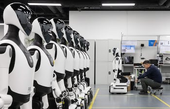 Un empleado trabaja en un robot durante una visita guiada para medios en la Plataforma Piloto de Verificación de Robots Humanoides de Pekín, en Pekín, China, el 20 de marzo de 2026.