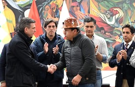 Fotografía cedida por la Presidencia de Bolivia que muestra al mandatario boliviano, Rodrigo Paz (i), durante la firma de un acuerdo para "pacificar" el país tras siete semanas de conflicto, saludando al dirigente de la Central Obrera Boliviana (COB), Mario Argollo (c), este viernes en La Paz (Bolivia).