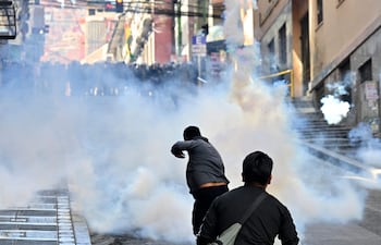 La policía antidisturbios dispara gases lacrimógenos contra manifestantes durante una protesta que exige la renuncia del presidente boliviano Rodrigo Paz, en La Paz, el 18 de mayo de 2026.