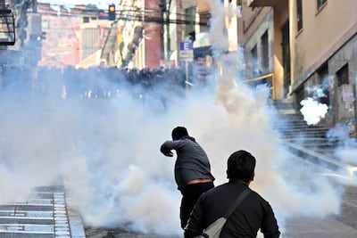 La policía antidisturbios dispara gases lacrimógenos contra manifestantes durante una protesta que exige la renuncia del presidente boliviano Rodrigo Paz, en La Paz, el 18 de mayo de 2026.