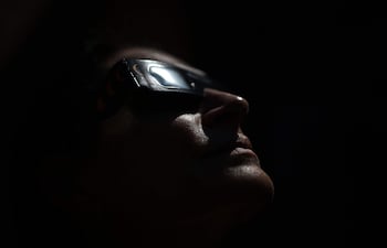 Una mujer se prueba unas gafas para observar directamente el Sol durante un eclipse solar.