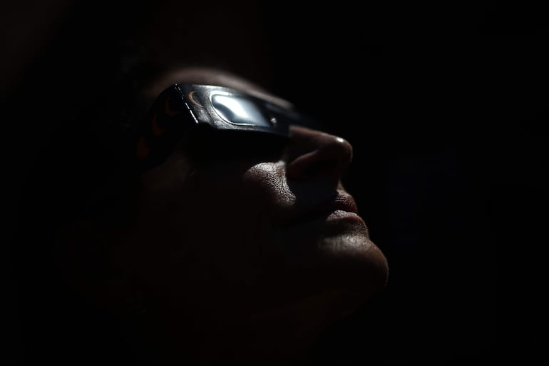 Una mujer se prueba unas gafas especiales para la observación directa del Sol en Béziers, en el sur de Francia, el 5 de agosto de 2026, antes del eclipse solar del 12 de agosto.