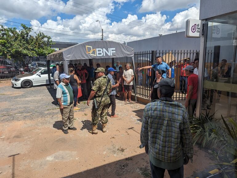 Funcionarios del Banco Nacional de Fomento (BNF) colocaron una carpa, pero muchos abuelos seguían en la fila resguardandose con cartones sobre sus cabezas.