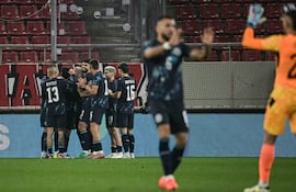 El el día de su cumpleaños, Diego Gómez recibe las felicitaciones de sus compañeros tras anotar el tanto del triunfo de Paraguay sobre Grecia.