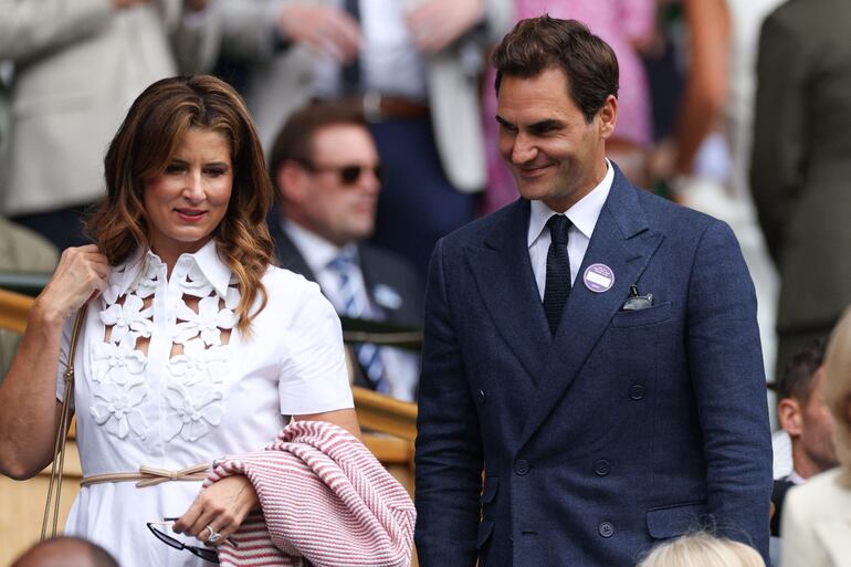 El suizo Roger Federer y su esposa Mirka Federer llegan al palco real de la cancha central antes del partido de tenis de cuarta ronda individual masculino entre el australiano Alex De Minaur y el serbio Novak Djokovic. (Adrian Dennis / AFP) 