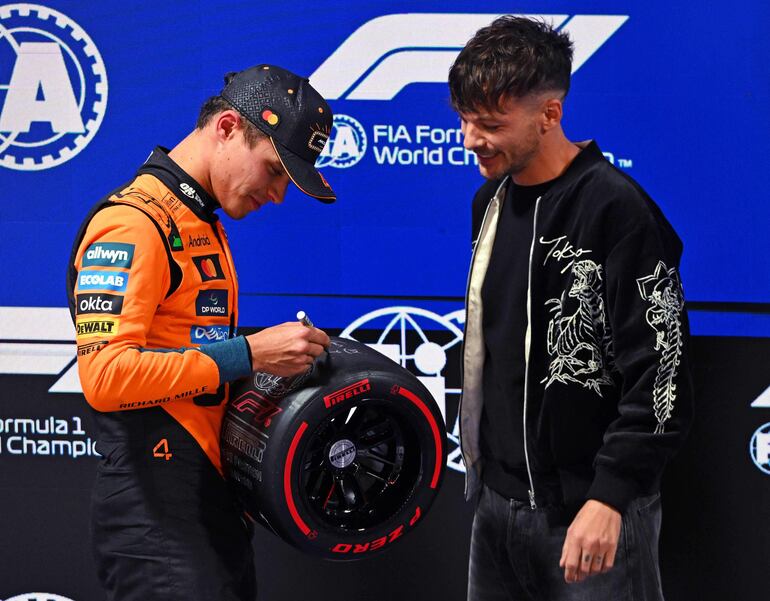 El británico Lando Norris, que obtuvo la pole position y es miembro de McLaren, junto a Louis Tomlinson durante la clasificación previa al Gran Premio de F1 de Las Vegas. (Rudy Carezzevoli/Getty Images/AFP)
