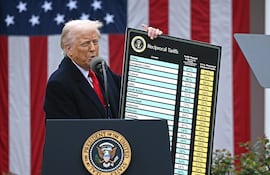 US President Donald Trump delivers remarks on reciprocal tariffs as US Secretary of Commerce Howard Lutnick holds a chart during an event in the Rose Garden entitled "Make America Wealthy Again" at the White House in Washington, DC, on April 2, 2025. Trump geared up to unveil sweeping new "Liberation Day" tariffs in a move that threatens to ignite a devastating global trade war. Key US trading partners including the European Union and Britain said they were preparing their responses to Trump's escalation, as nervous markets fell in Europe and America. (Photo by Brendan SMIALOWSKI / AFP)