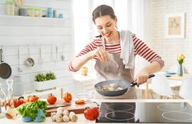 Mujer feliz cocinando.