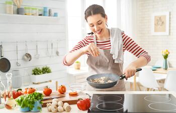 Mujer feliz cocinando.