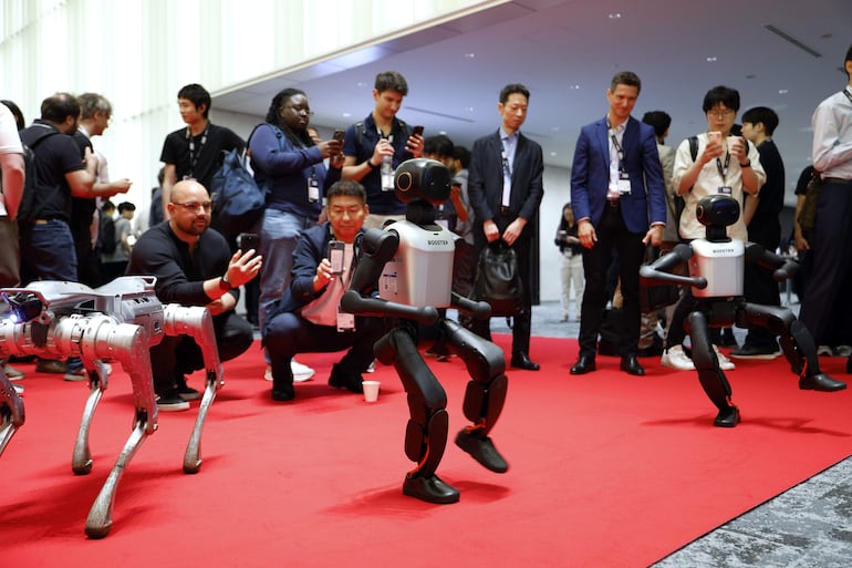 Los visitantes fotografían a los robots Booster K1 mientras realizan una coreografía durante la Humanoids Summit en Tokio, Japón, el 28 de mayo de 2026. La Humanoids Summit es un encuentro tecnológico anual centrado en el avance de la robótica humanoide. Los robots Booster K1 pertenecen a Booster Robotics.