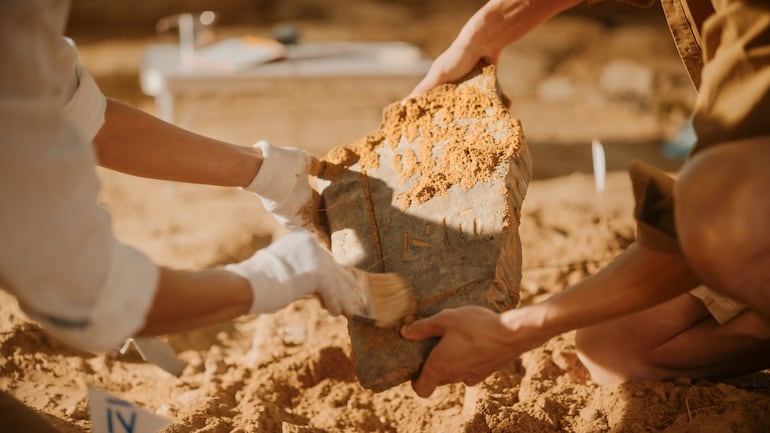 Dos arqueólogos trabajan en un sitio de excavación.