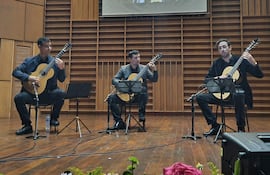 Rodrigo Benítez, José Carlos Cabrera y Favio Rodríguez tocan guitarra en escenario, con expresión tranquila y foco musical.