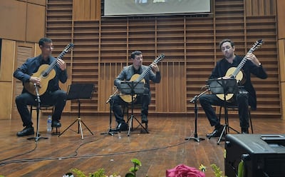 Rodrigo Benítez, José Carlos Cabrera y Favio Rodríguez tocan guitarra en escenario, con expresión tranquila y foco musical.