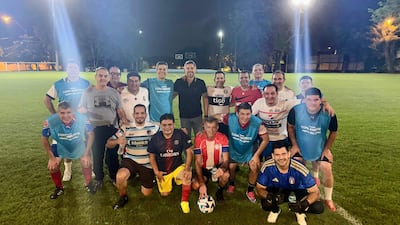 Yamil Esgai, Santiago Peña, Pedro Alliana y otros sonríen en una celebración deportiva, con camisetas de equipos y un balón de fútbol.