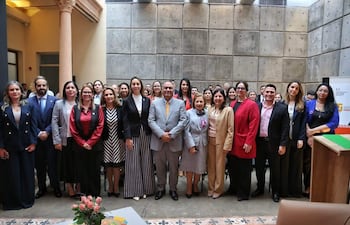 Javier Dejesús Esquivel al centro, con Alicia Pomata y Antonella Albertini, rodeados de mujeres, todos con expresiones felices en un ambiente institucional.
