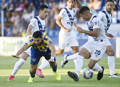 El delantero de Luqueño, Walter González, quien marcó dos goles, se cae ante el anticipo de Clever Pereira y el respaldo de Zaracho.