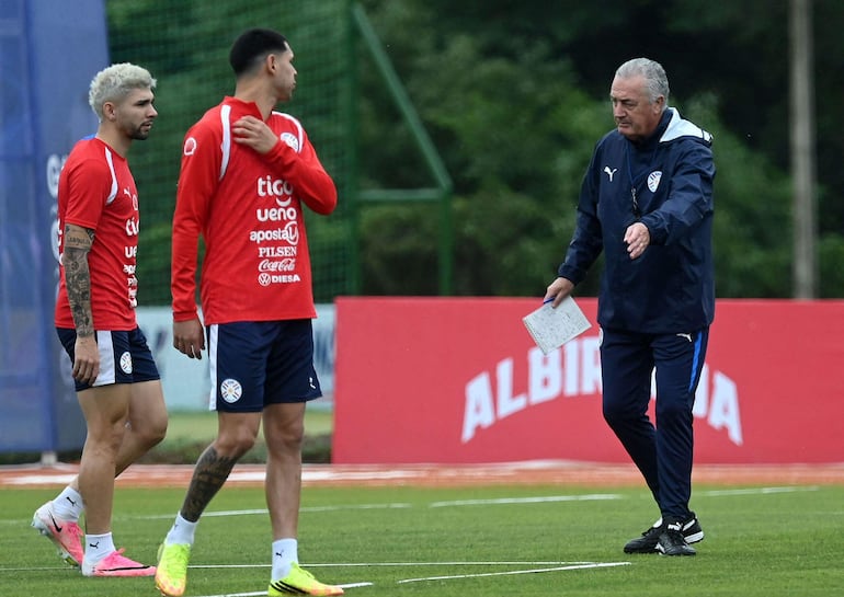 El seleccionador de Paraguay, Gustavo Alfaro, brinda indicaciones a los delanteros Julio Enciso y Gustavo Caballero.