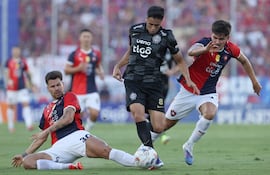 Gastón Giménez (i) y Lucas Quintana (d), jugadores de Cerro Porteño, disputan un balón con Alex Franco, futbolista de Olimpia, en un partido del superclásico por la sexta fecha del torneo Apertura 2026 de la Primera División de Paraguay en el estadio La Nueva Olla, en Asunción, Paraguay.