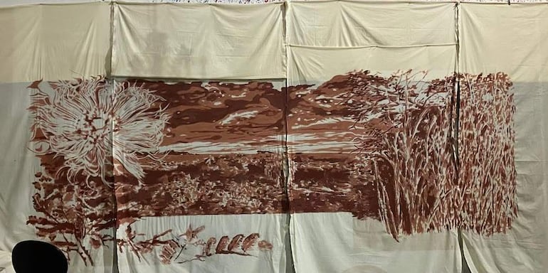 Tela grande con mural que simula paisaje natural, en tonalidades marrones, sin personas visibles en el ambiente interior.