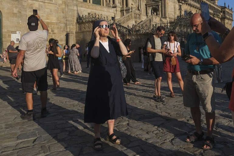 Multitud de personas se dieron cita en la Plaza del Obradoiro para ver el eclipse solar, este miércoles en Santiago de Compostela.