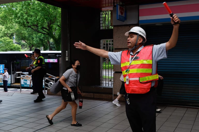 Trabajadores del metro de Taipéi guían a la gente a los refugios.