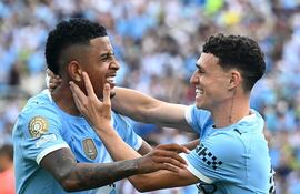 Phil Foden (d) celebra su gol, el cuarto para el Manchester City, junto al brasileño Savinho, quien marcó el quinto para el equipo inglés.