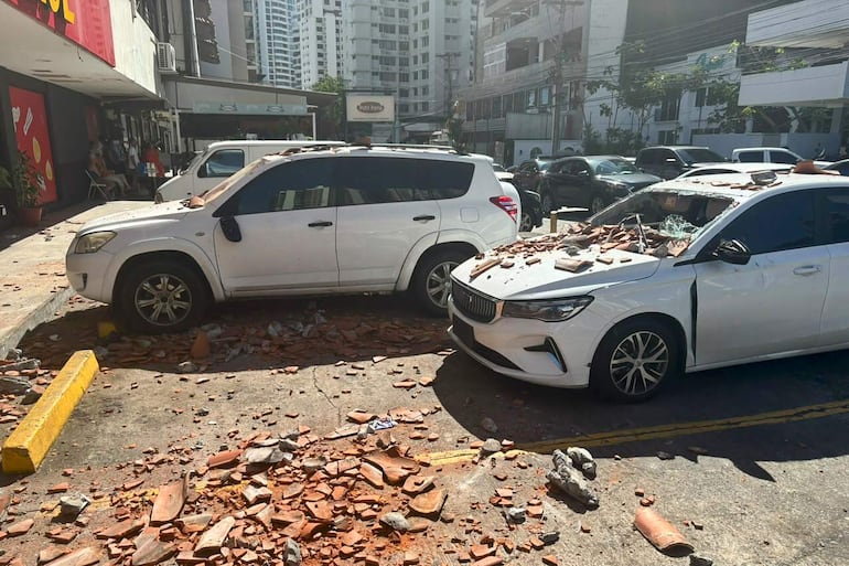 Vehículos afectados por restos de un edificio tras un terremoto de magnitud 7,7 con una profundidad de 10 kilómetros, según el Servicio Geológico de Estados Unidos (USGS), que sacudió este viernes, el sureste de Panamá, en la Ciudad de Panamá (Panamá).