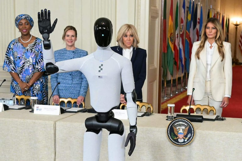 La primera dama de Frnacia (c) junto Melania Trump (d) junto a otras esposas de jefes de Estado, y el robot "Figure 3".