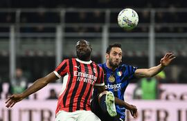 AC Milan's French midfielder #29 Youssouf Fofana (L) fights for the ball with Inter Milan's Turkish midfielder #20 Hakan Calhanoglu during the Italian Cup semi-final first leg football match between AC Milan and Inter Milan at San Siro stadium in Milan, on April 2, 2025. (Photo by Isabella BONOTTO / AFP)