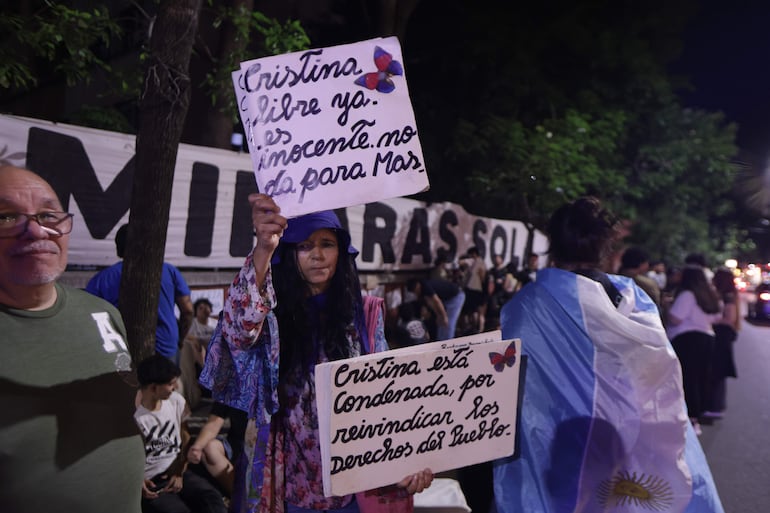 Una persona sostiene carteles a las afueras del Sanatorio Otamendi este sábado, en Buenos Aires (Argentina). La expresidenta argentina Cristina Fernández fue ingresada en un hospital de Buenos Aires con un cuadro de apendicitis por el cual debió ser sometida a una intervención, según informaron a EFE fuentes del entorno de la exmandataria, que cumple desde junio pasado en su domicilio una pena a seis años de prisión.