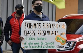 Afiliados a la Otep-Sn piden la suspensión de las clases presenciales esta mañana, en una manifestación frente a la sede del MEC, en el microcentro de Asunción.