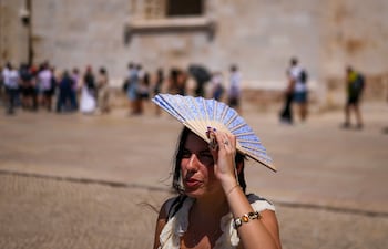 Una mujer se cubre la cabeza con un abanico frente al Monasterio de los Jerónimos, en Belém, durante una ola de calor en Lisboa el 27 de mayo de 2026. Europa occidental enfrentó otro día de temperaturas récord, mientras una ola de calor elevaba los termómetros muy por encima de los valores habituales para mayo.