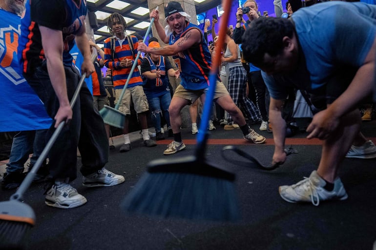 Euforia total en las calles de Nueva York con los aficionados de los Knicks con sus escobas.