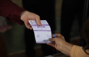 Una persona entrega una tarjeta electoral durante las elecciones municipales en Asunción.
