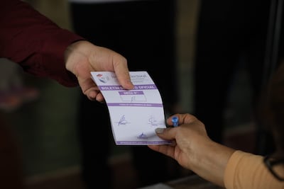 Una persona entrega una tarjeta electoral durante las elecciones municipales en Asunción.