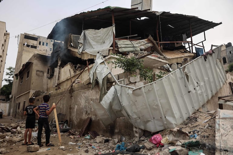 Niños observan un edificio destruido por un bombardeo israelí en la Ciudad de Gaza.