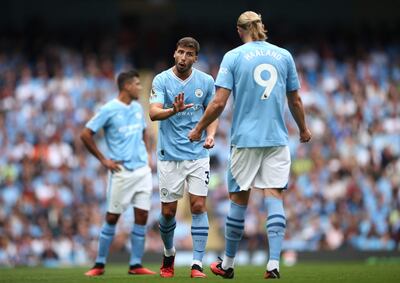 El portugués Rúben Dias (i), jugador del Manchester City, conversa con el noruego Erling Haaland, durante el partido contra el Fulham por la cuarta fecha de la Premier League 2023-2024 en el estadio Etihad, en Manchester.