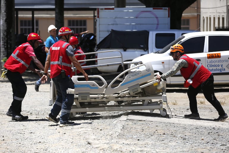 Un grupo de brigadistas traslada una camilla este jueves en el Hospital Universitario del Valle (HUV) afectado tras el terremoto de magnitud 7,4 en Cali (Colombia). El HUV, sufrió el derrumbe parcial de una de sus alas, según autoridades de Cali.