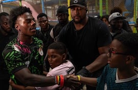 El youtuber y streamer estadounidense Darren Jason Watkins Jr., más conocido como IShowSpeed (izq.), es abrazado por un joven admirador durante un evento en el centro comercial Admiralty Mall, en Lagos, el 21 de enero de 2026.