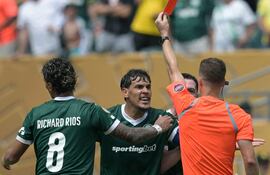 El paraguayo Gustavo Gómez (32 años) reclama al juez francés Francois Letexier al ver la roja. Richard Ríos trata de apaciguar la situación.