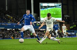 Peterborough's Swedish striker #19 Gustav Lindgren (R) shoots the ball but misses to score during the English FA Cup third round football match between Everton and Peterborough United at Goodison Park in Liverpool, north west England on January 9, 2025. (Photo by Oli SCARFF / AFP) / RESTRICTED TO EDITORIAL USE. No use with unauthorized audio, video, data, fixture lists, club/league logos or 'live' services. Online in-match use limited to 120 images. An additional 40 images may be used in extra time. No video emulation. Social media in-match use limited to 120 images. An additional 40 images may be used in extra time. No use in betting publications, games or single club/league/player publications. /