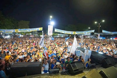Multitud enérgica en la plaza, con pancartas y banderas mientras escuchan a Manuel Achucarro.