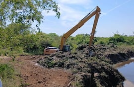 Una retro excavadora brazo largo trabaja en el canal de Arroyo Hondo,distrito de Humaitá.
