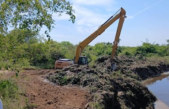 Una retro excavadora brazo largo trabaja en el canal de Arroyo Hondo,distrito de Humaitá.