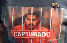 Una persona viste una camiseta con la imagen del presidente de Venezuela, Nicolás Maduro, con la frase "Capturado" durante una manifestación en apoyo al presidente de Estados Unidos, Donald Trump, este domingo en Houston, Texas (Estados Unidos).