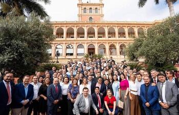 Grupo de intendentes de Paraguarí, vestidos formalmente, reunidos frente a un edificio gubernamental, con expresiones mixtas de felicidad y tristeza.