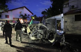 La policía pasa junto a vehículos destruidos por un misil lanzado desde Irán, en Rosh Haayin, Israel, el 28 de febrero de 2026.