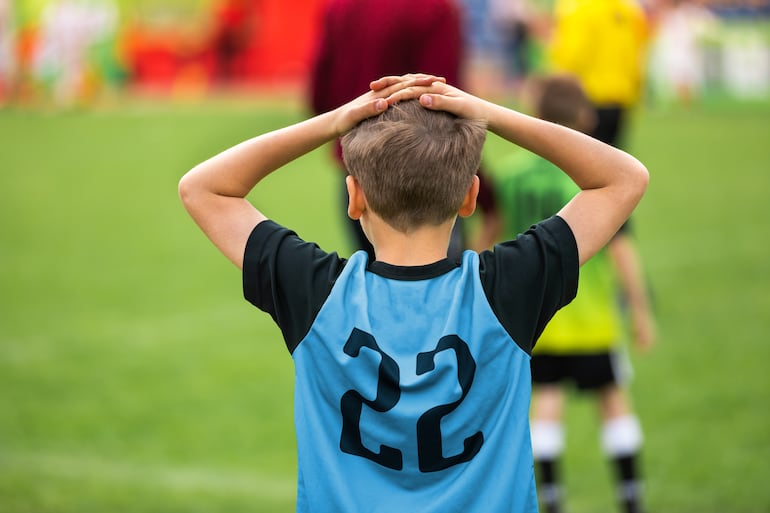 Niño triste tras la derrota en un juego deportivo, imagen ilustrativa.