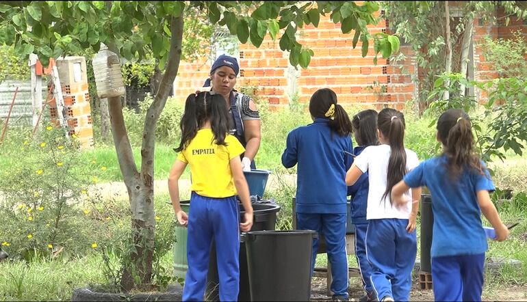 Niñas entregan su plato para que se laven, luego del almuerzo de Hambre Cero.